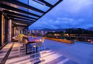 Hilton Bogota Corferias في بوغوتا: شرفة على طاولة وكراسي في مبنى