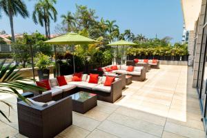 un patio con sofás y sombrillas en un edificio en Hilton Garden Inn Barranquilla, en Barranquilla