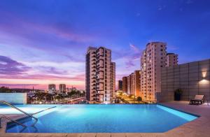 a swimming pool on top of a building with a city skyline at Hilton Garden Inn Barranquilla in Barranquilla