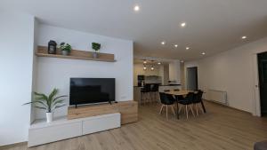 a living room with a television and a table with chairs at Hydros Apartments - Bike Friendly in Ripoll