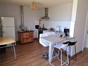 een keuken met een tafel en een aantal witte stoelen bij Casa do Souto - Douro e Marão 