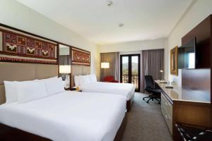a hotel room with two beds and a flat screen tv at Hilton Garden Inn Cusco in Cusco +64 photos