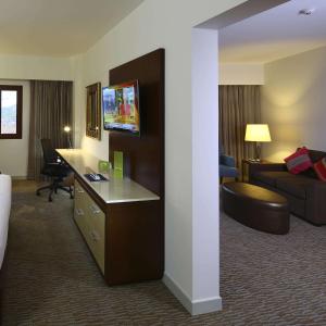 ein Hotelzimmer mit einem Bett, einem Schreibtisch und einem Sofa in der Unterkunft Hilton Garden Inn Cusco in Cusco