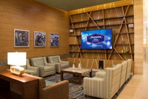 uma sala de espera com uma televisão e sofás em Hampton Inn by Hilton Villahermosa em Villahermosa