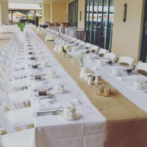 uma mesa longa com mesas brancas e cadeiras brancas em Hilton Barbados Resort em Bridgetown