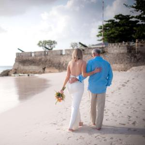 un homme et une femme se promenant sur la plage dans l'établissement Hilton Barbados Resort, à Bridgetown