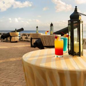 a table with a glass of juice on top of it at Hilton Barbados Resort in Bridgetown