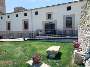 a large building with two potted plants in a yard at El Esquileo in Buitrago del Lozoya