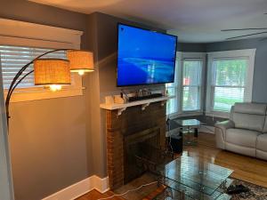 a living room with a fireplace and a flat screen tv at Spacious 5 Bed 2 Bath near Syracuse University and Downtown Syracuse With Lots of Amenities and Free Parking in Syracuse