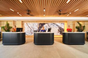 een groep mensen die aan een bureau in een lobby zitten bij Hilton Hotel Tahiti in Papeete