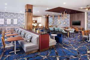 a hotel lobby with tables and chairs and a bar at Hampton Inn Boston Seaport District in Boston