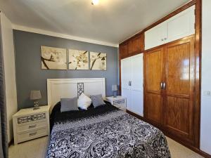 sypialnia z łóżkiem i drewnianą szafką w obiekcie Apartamento ANTOSOL w mieście Playa Honda