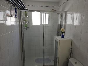 a white bathroom with a shower and a toilet at Apartamento ANTOSOL in Playa Honda