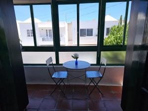 einen Tisch und Stühle in einem Zimmer mit Fenster in der Unterkunft Apartamento ANTOSOL in Playa Honda