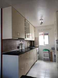 eine Küche mit weißen Schränken, einer Spüle und einem Geschirrspüler in der Unterkunft Apartamento ANTOSOL in Playa Honda