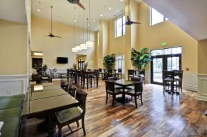 a dining room with tables and chairs and windows at Hampton Inn & Suites North Charleston-University Boulevard in Charleston