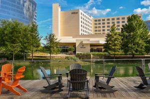 un groupe de chaises et de tables devant un bâtiment dans l'établissement Hilton Dallas/Plano Granite Park, à Plano