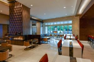 a restaurant with tables and chairs and a lobby at Hilton Dallas/Plano Granite Park in Plano