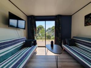 a room with two beds and a table and a window at Cottage du Lac 63 in Olonzac