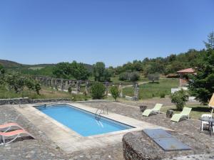 a swimming pool in a yard with chairs around it at Quinta da Rica-Fé in Bragança