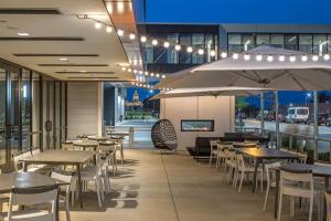 德梅因Hilton Des Moines Downtown的一间带桌椅和灯光的餐厅