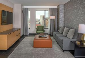 a living room with a couch and a tv at Hilton Des Moines Downtown in Des Moines