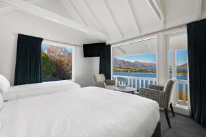 1 dormitorio con 2 camas y ventana grande en Lakeview Colonial Motel en Queenstown