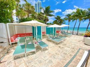 The Diplomat Beach Resort Hollywood, Curio Collection by Hilton في هوليوود: صف من الكراسي والمظلات على الشاطئ
