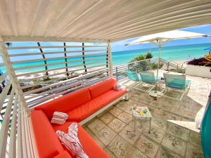 a red couch sitting on a balcony with the beach at The Diplomat Beach Resort Hollywood, Curio Collection by Hilton in Hollywood