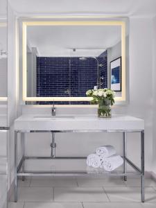 a bathroom with a sink with a mirror and towels at Hilton Fort Lauderdale Marina in Fort Lauderdale