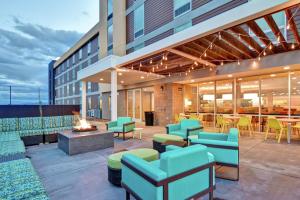 a patio with a fire pit and chairs and a building at Home2 Suites By Hilton Helena in Helena