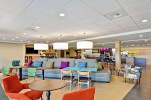 a waiting room with a couch and tables and chairs at Home2 Suites By Hilton Helena in Helena