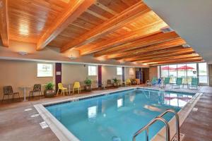 a pool in a hotel with chairs and a table at Home2 Suites By Hilton Helena in Helena