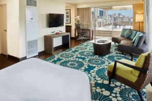 a room with a living room with a couch and a tv at DoubleTree by Hilton Alana - Waikiki Beach in Honolulu