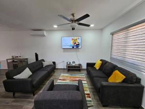 a living room with two couches and a ceiling fan at Colinas Casa en la Playa in Puerto Peñasco