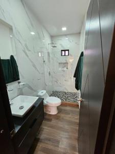 a bathroom with a white toilet and a sink at Colinas Casa en la Playa in Puerto Peñasco