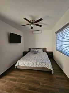 1 dormitorio con 1 cama y ventilador de techo en Colinas Casa en la Playa en Puerto Peñasco
