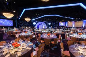 a large banquet hall filled with tables and chairs at The Beverly Hilton in Los Angeles