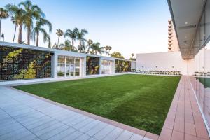 an indoor lawn in a building with palm trees at The Beverly Hilton in Los Angeles