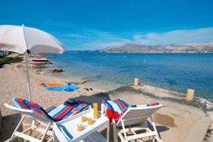 una playa con dos sillas y una sombrilla y el agua en Apartments by the sea Okrug Gornji, Ciovo - 8663 en Trogir