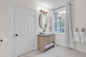 a white bathroom with a sink and a mirror at Beautiful Lakeside Haven in Port Hope +20 photos