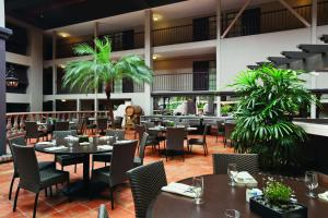 een vrouw in een restaurant met tafels en stoelen bij Embassy Suites by Hilton Napa Valley in Napa