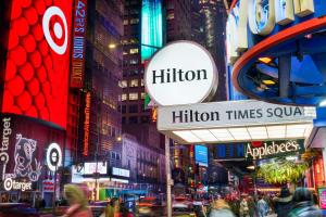 una concurrida calle por la noche con tráfico y edificios en Hilton New York Times Square en Nueva York