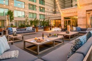 an outdoor patio with couches and tables in a building at The Duniway Portland, A Hilton Hotel in Portland