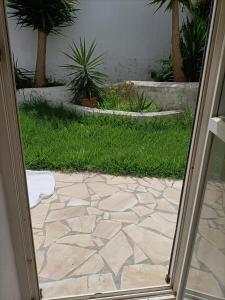 an open door to a patio with grass and plants at Casa James in Vejer de la Frontera