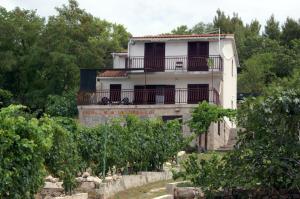 ein altes Haus mit einem Balkon und Bäumen in der Unterkunft Apartments by the sea Sepurine, Prvic - 4238 in Prvić Šepurine