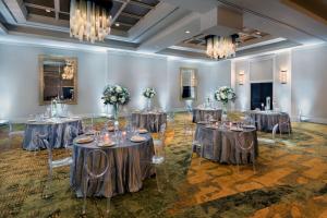 um salão de baile com mesas e cadeiras numa sala com lustres em The Inn at Penn, A Hilton Hotel em Filadélfia