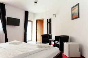 ラシュノフにあるComplex Turistic Max Internationalのベッドルーム1室(ベッド1台、椅子2脚、テーブル付)