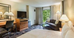 Habitación de hotel con cama, escritorio y TV. en DoubleTree by Hilton Durango en Durango