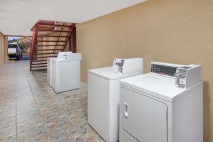 una lavandería con lavadoras y secadoras blancas. en Super 8 by Wyndham Kingsville, en Kingsville